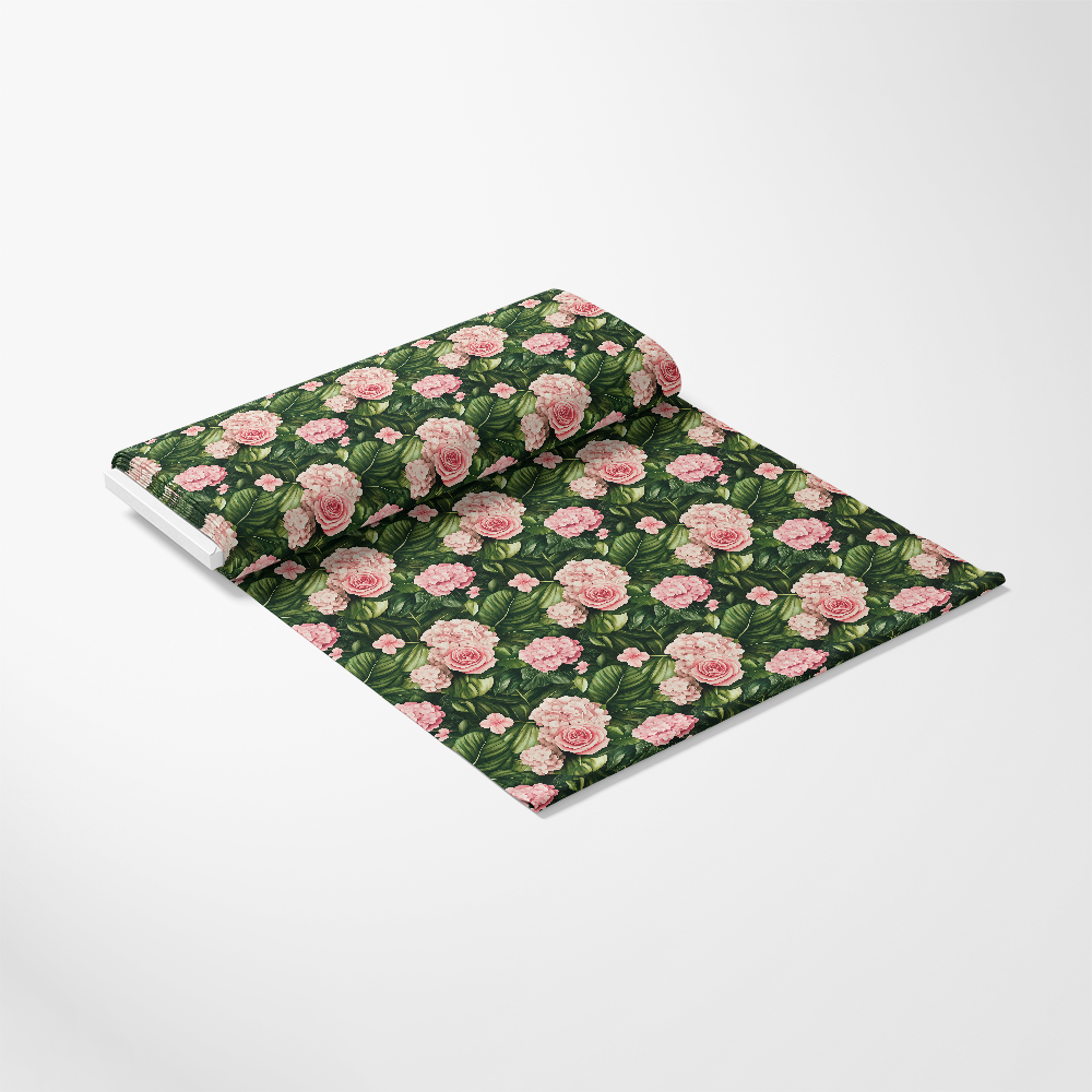 A roll of decorative fabric with a floral pattern of pink roses and green leaves on a dark background, partially unfurled on a white surface.