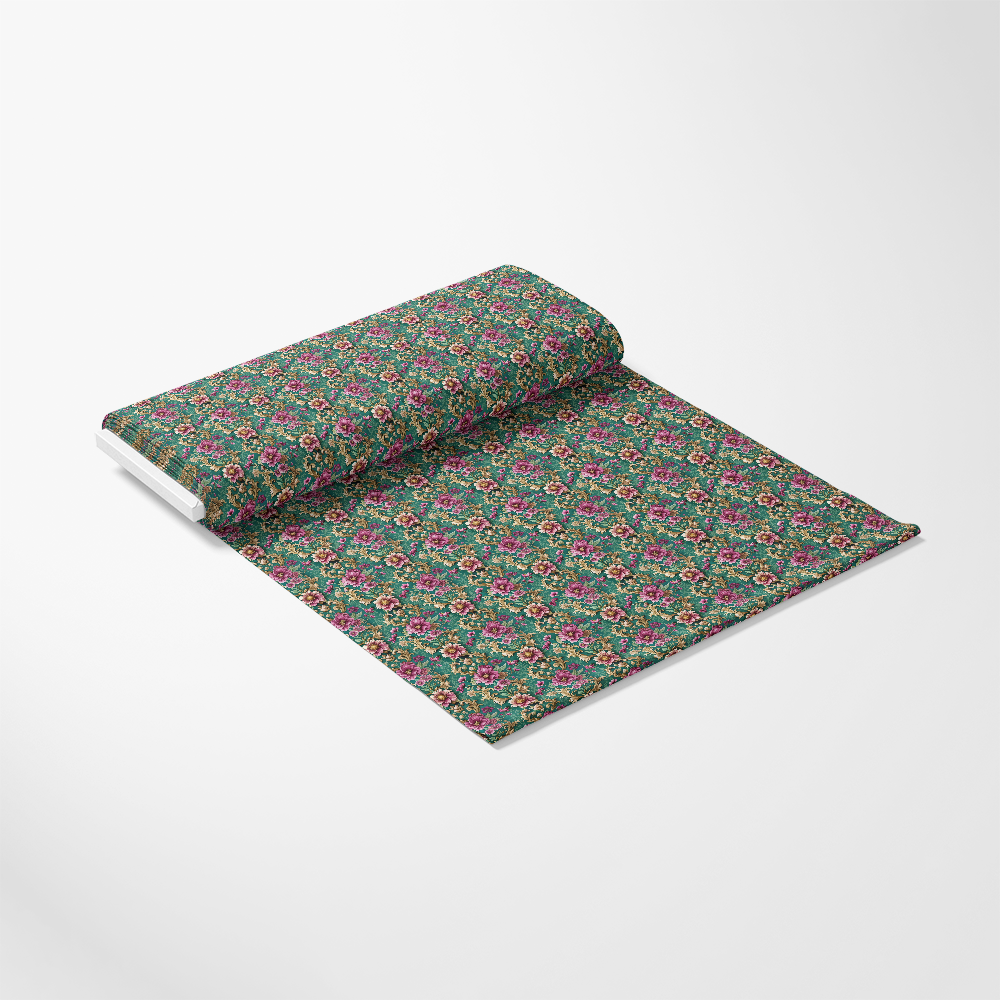 A roll of green fabric with a repeating pattern of small pink and red flowers, partially unrolled on a white background.