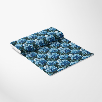 A roll of wallpaper featuring a blue hydrangea pattern on a white background.
