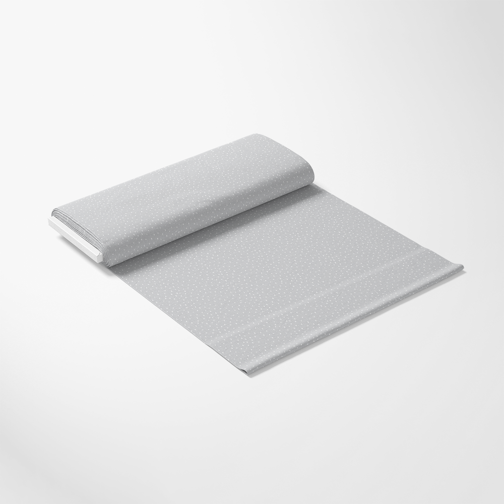 A folded, light gray sheet with a subtle white dotted pattern is laid out on a plain white background.