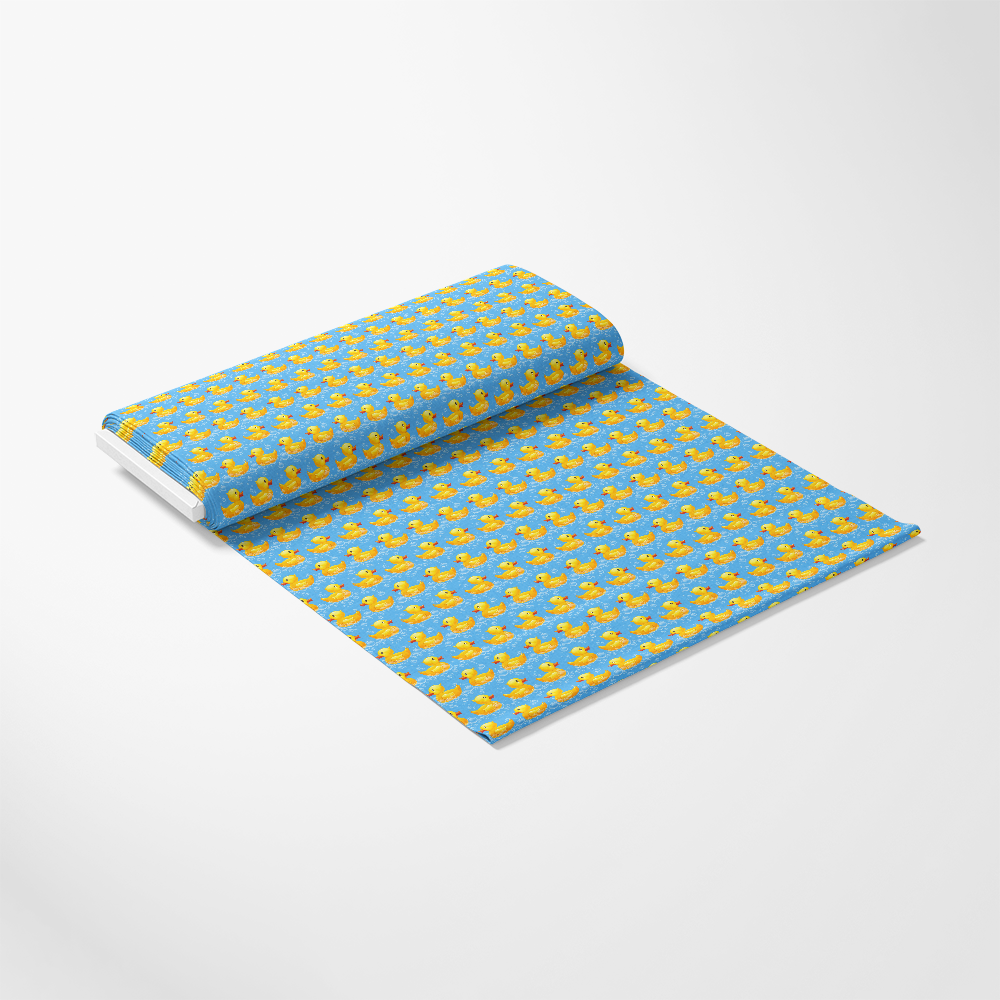 Roll of wallpaper with a pattern of small yellow rubber ducks on a blue background, partially unrolled.