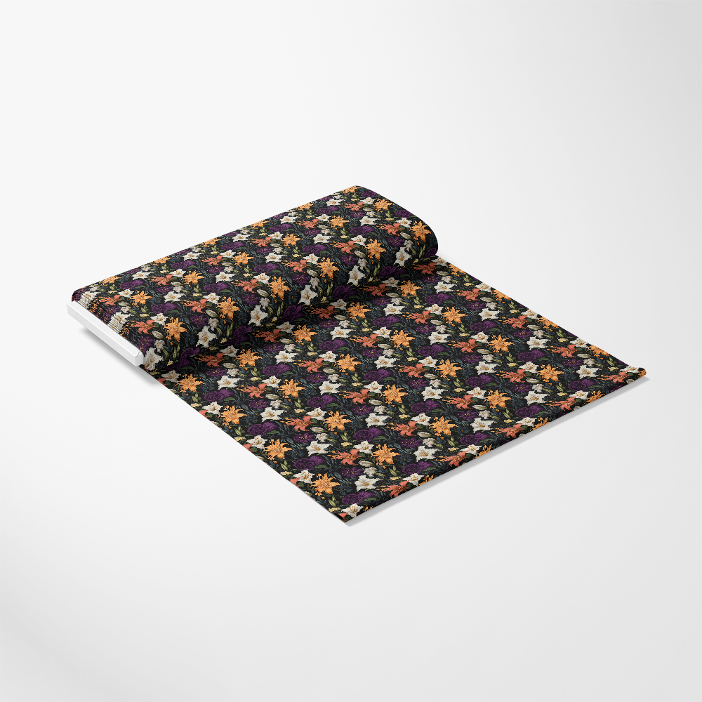 A rolled-out piece of fabric or wallpaper features a dense, colorful floral pattern on a dark background, displayed on a plain white surface.