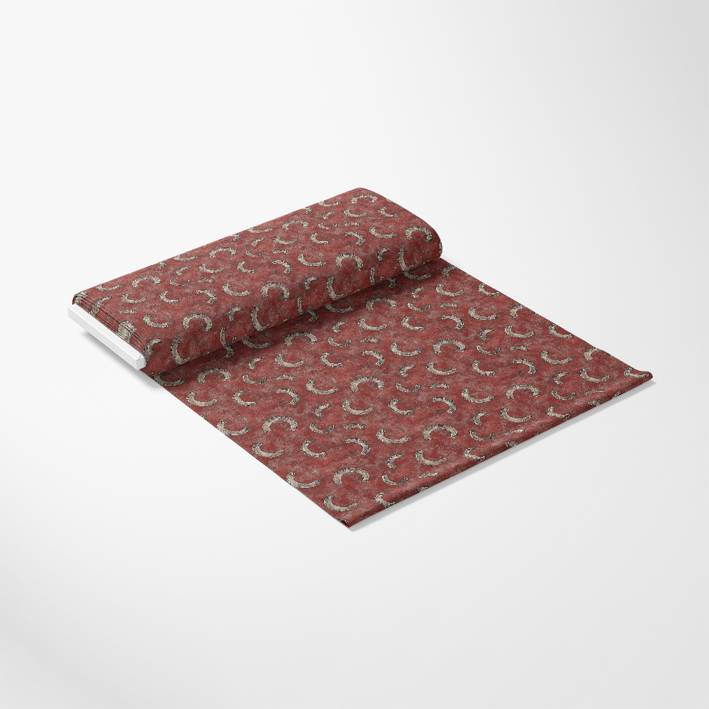 A roll of maroon wallpaper with a subtle, repeating horseshoe pattern is partially unrolled on a white background.