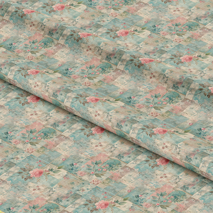 A fabric with a soft, vintage-inspired patchwork design featuring muted pastel squares, floral patterns, and scattered pink roses, arranged in a repeating grid. The fabric is gently folded.