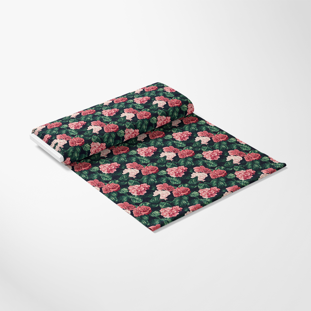 A roll of fabric with a floral pattern featuring pink roses and green leaves on a dark background, partially unrolled with the pattern visible.