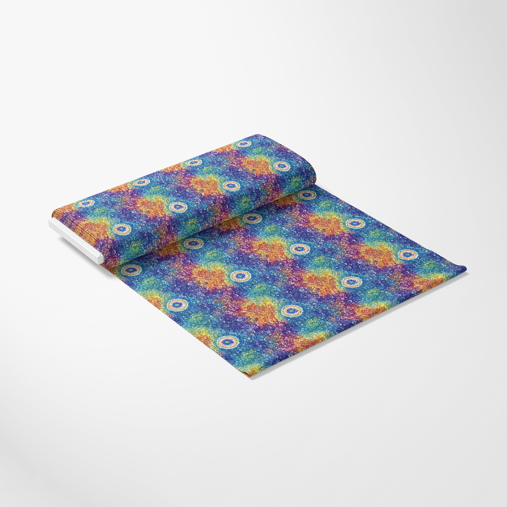 A colorful roll of fabric is unrolled on a white surface, featuring a vibrant pattern with circular motifs.