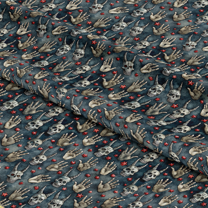 A piece of dark blue fabric featuring a repeating pattern of skulls, skeletal hands in various gestures, and small red star-like symbols. The fabric is slightly wrinkled and folded.