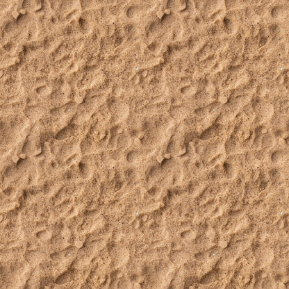 A close-up view of textured sand with small ripples and scattered pebbles.