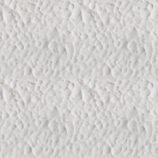 Close-up view of white sand with a pattern of small, uneven ridges and shallow depressions.