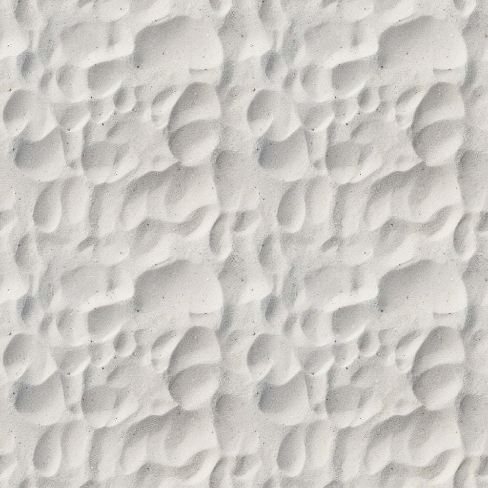 Close-up of white sand with rippled patterns and shadows.