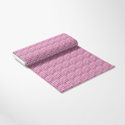 A roll of pink and white checkered fabric partially unrolled on a plain background.