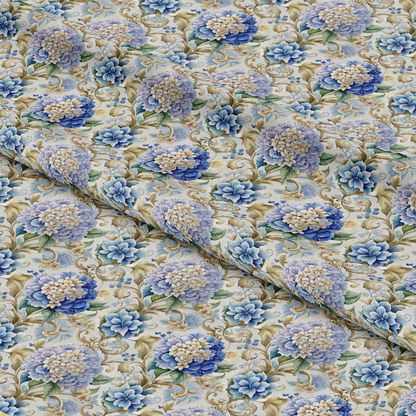 A close-up of fabric with a repeating floral pattern featuring blue and cream flowers, green leaves, and gold scroll designs. The fabric is gently folded, creating visible creases and texture.