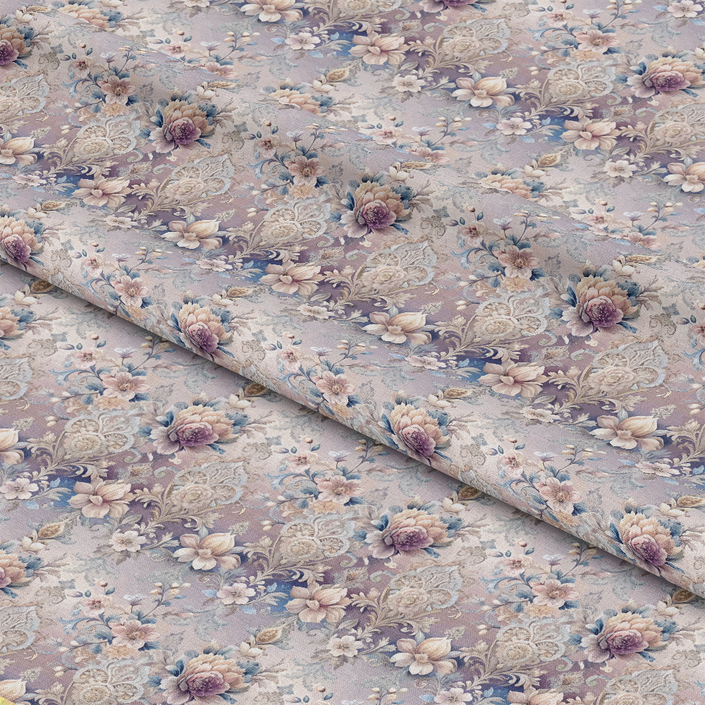 Folded fabric with a vintage floral pattern featuring pink, purple, and white flowers, green leaves, and intricate beige lace designs on a muted lavender background. The fabric appears soft and slightly textured.