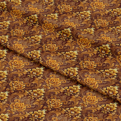 A piece of fabric with an ornate floral pattern in shades of gold and yellow on a brown background, featuring large flowers, leaves, and swirling vines. The fabric is slightly folded in the middle.