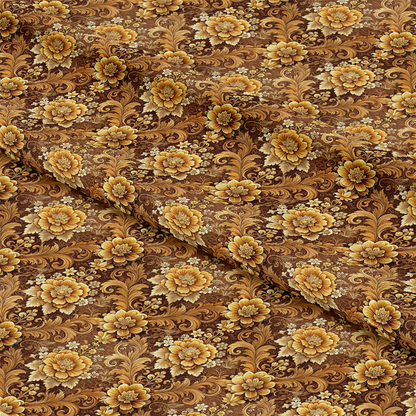 A close-up of brown fabric featuring an ornate floral pattern in shades of gold, tan, and yellow, with large and small flowers and swirling leaves, some folds present in the fabric.