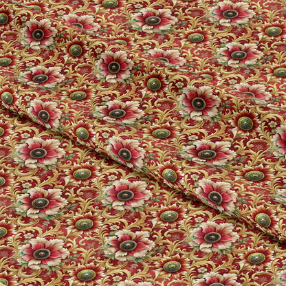 A piece of fabric featuring a repeating floral pattern in shades of red, green, gold, and cream on a red background. The fabric is slightly folded, creating visible creases and texture.
