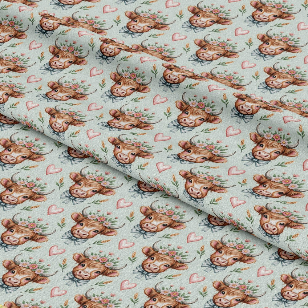 - Highland Cow Heads Pattern 3 Quilting Cotton Fabric  
- Brown cow faces  
- Floral crowns  
- Pink hearts  
- Light blue background  
- Soft texture  
- Quilting material  
- Cotton textile  
- Rustic design  
- Cute animal print  
- Pastel colors
